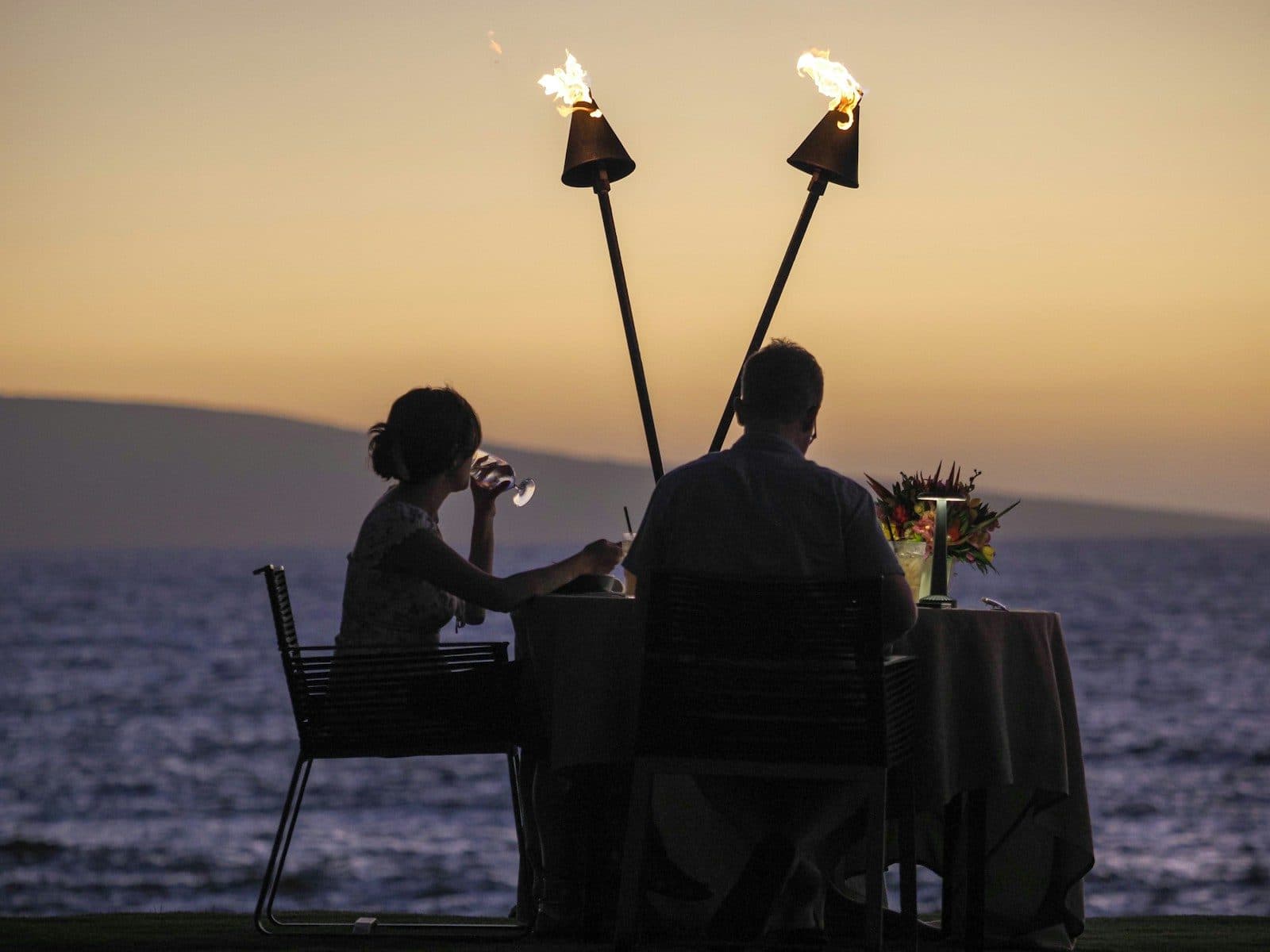 A candle-lit dinner for two by the sea at sunset