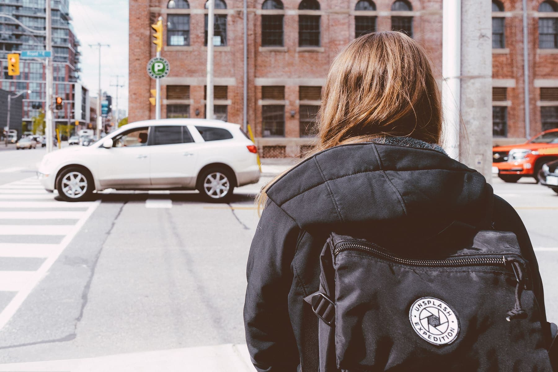 Traveler with a backpack seen from behind on a city street