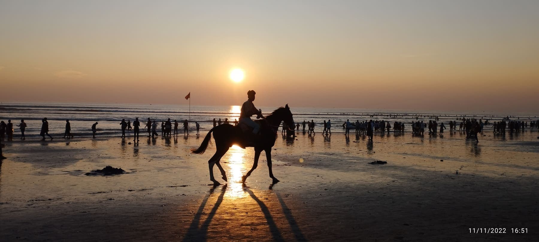 Rider on horseback silhouetted on a beach at sunset