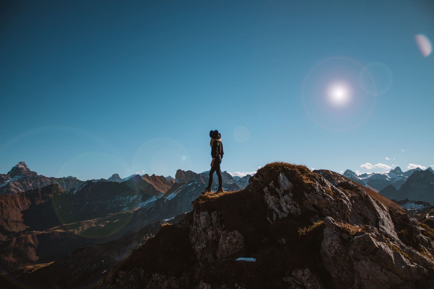 Hiker silhouetted on a mountain summit at dusk
