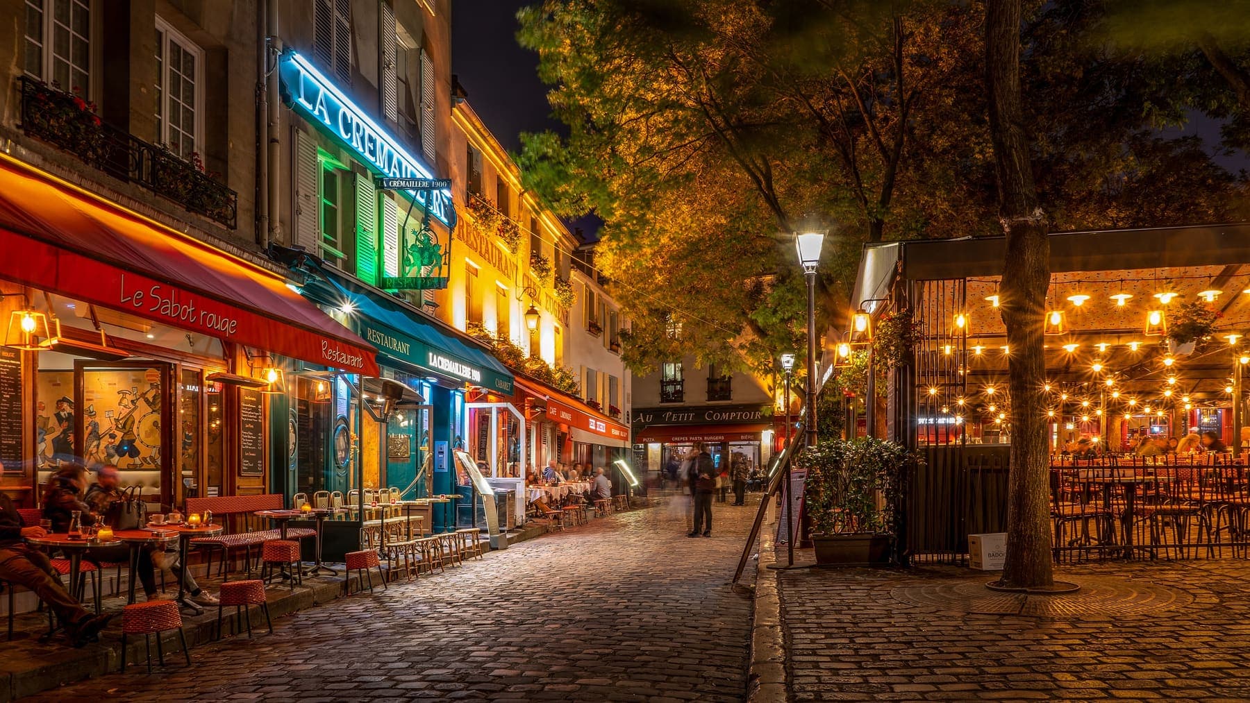 Restaurant terraces glowing at night in Montmartre, Paris